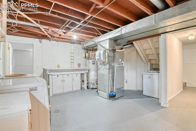 unfinished below grade area with heating unit, gas water heater, washer and dryer, and fridge