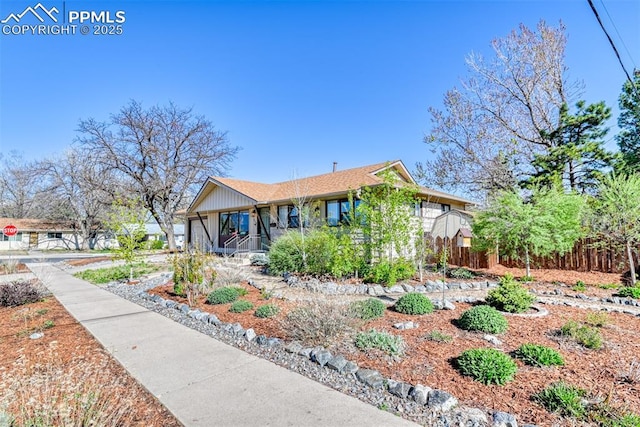 view of front of home with a porch and fence