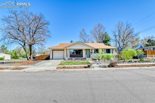 ranch-style home with an attached garage, fence, and driveway