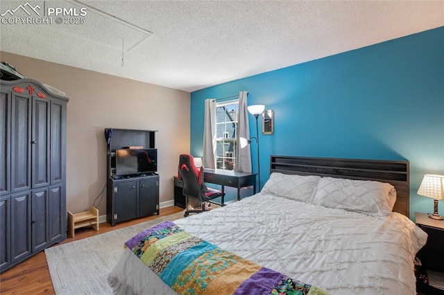 3319 Queen Anne Way, Colorado Springs, CO 80917 - bedroom with attic access, a textured ceiling, and wood finished floors