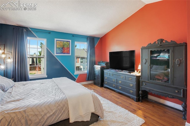 3319 Queen Anne Way, Colorado Springs, CO 80917 - bedroom with a textured ceiling, wood finished floors, vaulted ceiling, and multiple windows