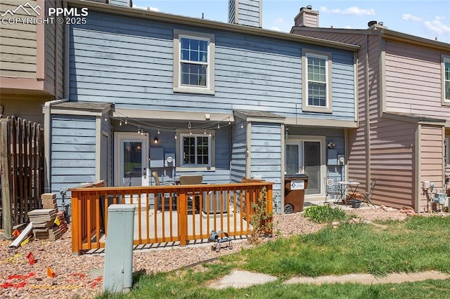 3319 Queen Anne Way, Colorado Springs, CO 80917 - back of property with a wooden deck, a chimney, and fence
