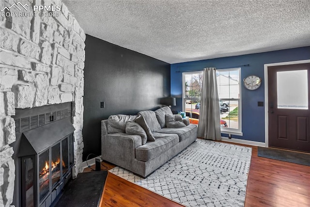 3319 Queen Anne Way, Colorado Springs, CO 80917 - living room with a textured ceiling, wood finished floors, and a fireplace