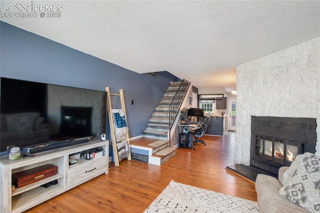 3319 Queen Anne Way, Colorado Springs, CO 80917 - living room with stairs, a textured ceiling, wood finished floors, and a fireplace