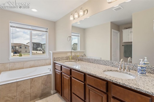 full bathroom with a sink, a wealth of natural light, and visible vents