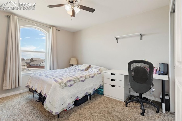 bedroom with a ceiling fan, baseboards, and light colored carpet