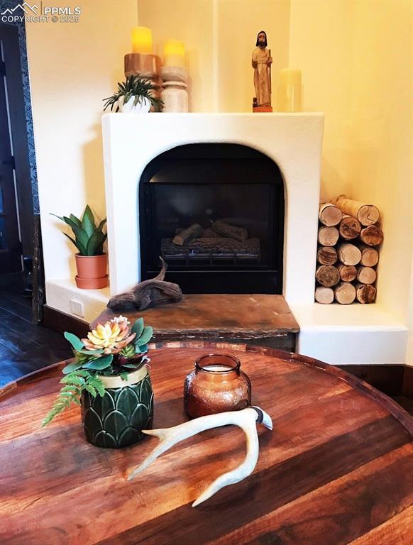 details with a fireplace with raised hearth and wood finished floors