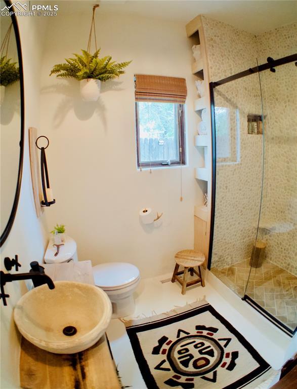 bathroom with a shower stall and toilet