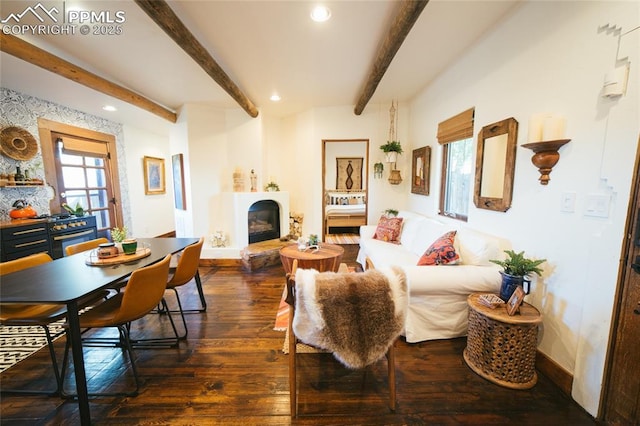 living room featuring dark wood-style flooring, beam ceiling, baseboards, a fireplace with raised hearth, and recessed lighting