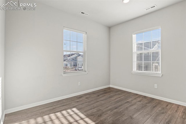 empty room with recessed lighting, baseboards, visible vents, and wood finished floors