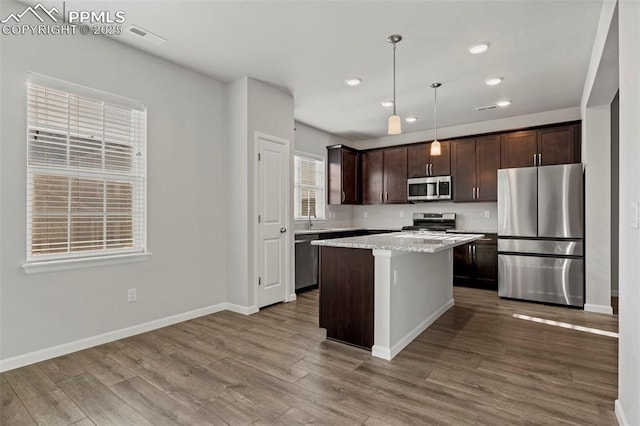 kitchen featuring wood finished floors, dark brown cabinets, baseboards, recessed lighting, and appliances with stainless steel finishes