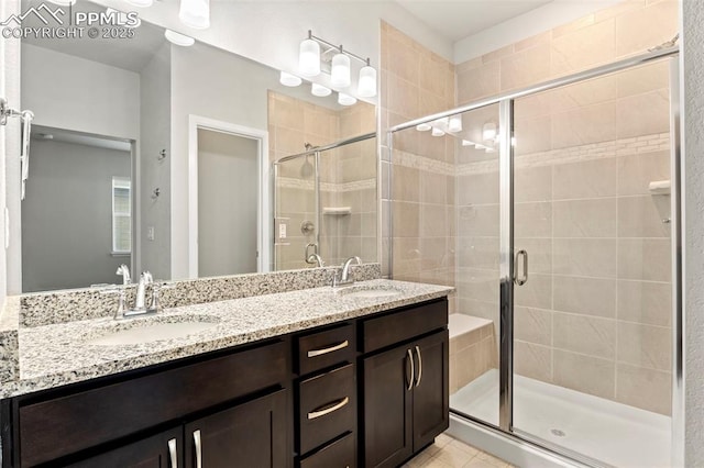 bathroom with double vanity, a sink, a stall shower, and tile patterned floors