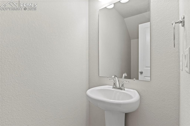 bathroom with a sink and a textured wall