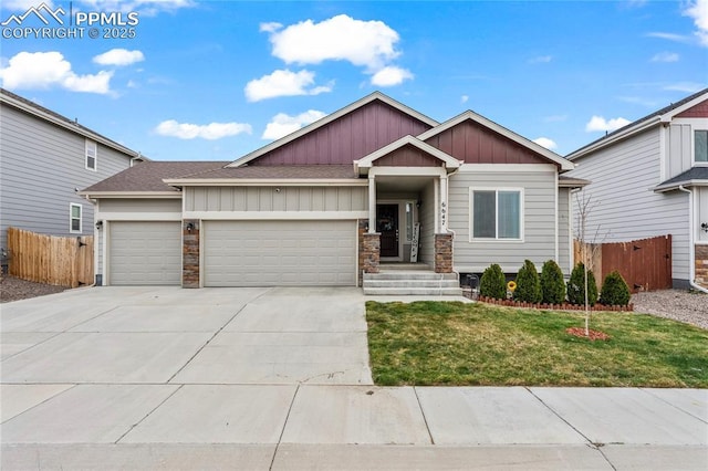 6647 Weiser Dr, Colorado Springs, CO 80925 - craftsman house with board and batten siding, driveway, a front yard, a garage, and fence
