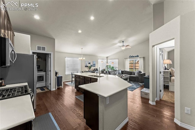 6647 Weiser Dr, Colorado Springs, CO 80925 - kitchen with a large island with sink, stainless steel microwave, ceiling fan with notable chandelier, and dark wood finished floors