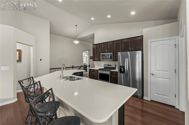 6647 Weiser Dr, Colorado Springs, CO 80925 - kitchen featuring dark wood-style flooring, a sink, stainless steel appliances, lofted ceiling, and a center island with sink