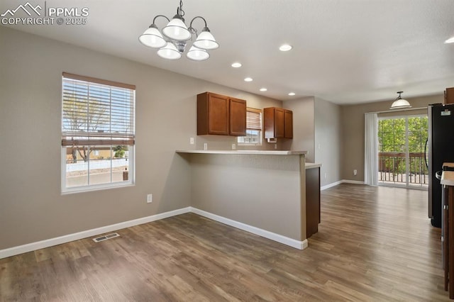 kitchen featuring baseboards, freestanding refrigerator, dark wood finished floors, and a chandelier
