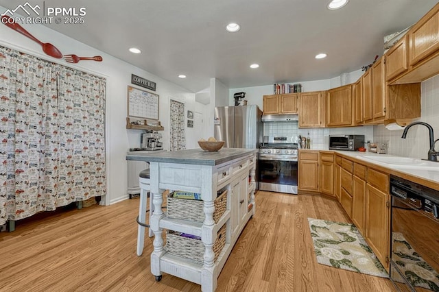 16440 Eastonville Rd, Elbert, CO 80106 - kitchen featuring appliances with stainless steel finishes, under cabinet range hood, light wood-style floors, backsplash, and recessed lighting