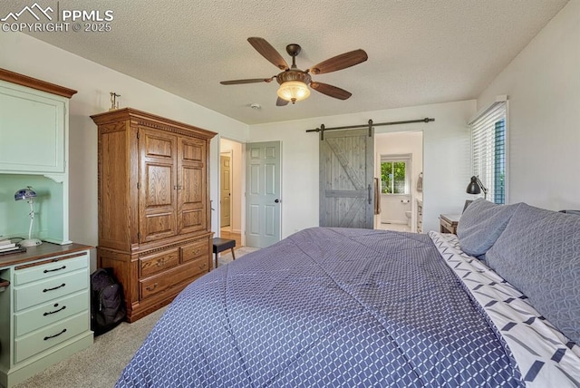 16440 Eastonville Rd, Elbert, CO 80106 - bedroom with a textured ceiling, a barn door, connected bathroom, ceiling fan, and light carpet