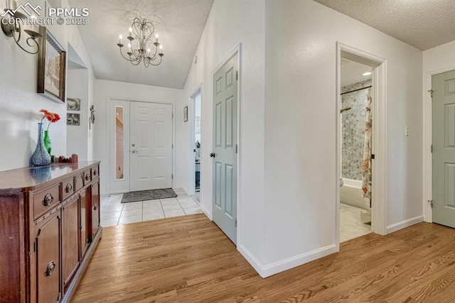 16440 Eastonville Rd, Elbert, CO 80106 - foyer with a textured ceiling, a chandelier, light wood-type flooring, and vaulted ceiling