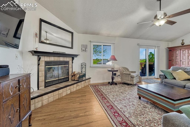 16440 Eastonville Rd, Elbert, CO 80106 - living room featuring vaulted ceiling, wood finished floors, a fireplace, plenty of natural light, and a ceiling fan