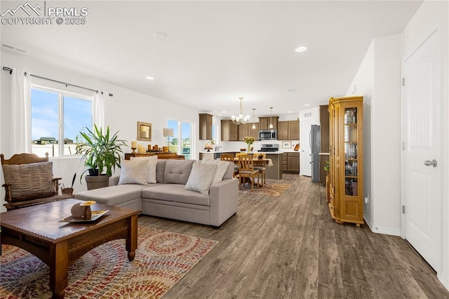living room featuring a chandelier, wood finished floors, visible vents, and recessed lighting