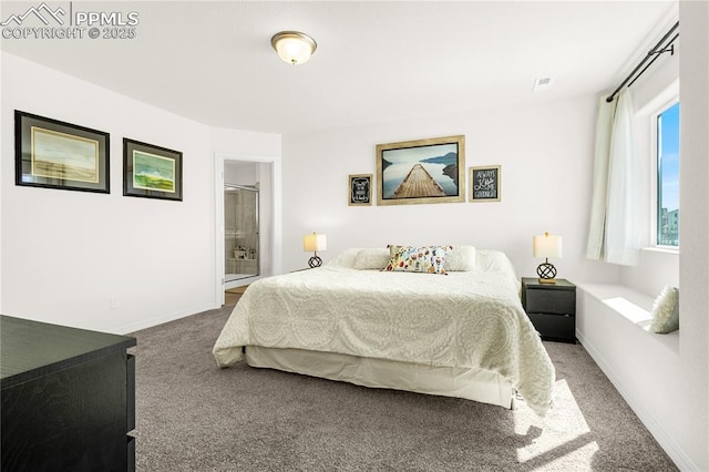 carpeted bedroom with ensuite bathroom and baseboards
