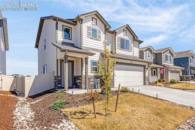 view of front of house featuring fence, an attached garage, stone siding, a residential view, and driveway