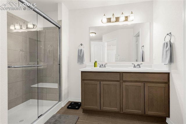 full bathroom with a sink, baseboards, and a shower stall