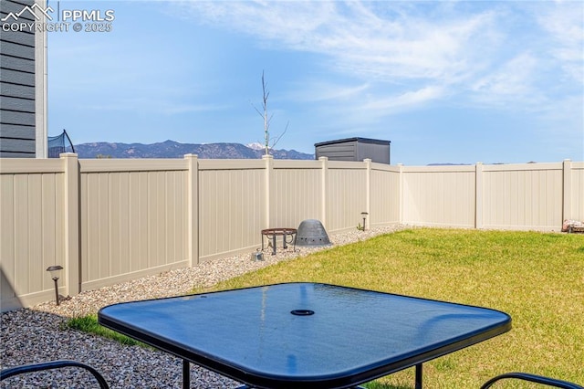 view of yard featuring a mountain view and a fenced backyard