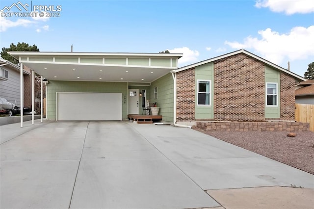 view of front of property featuring an attached garage, brick siding, and driveway