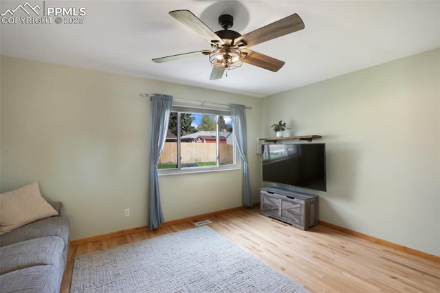 living area featuring ceiling fan, baseboards, visible vents, and wood finished floors