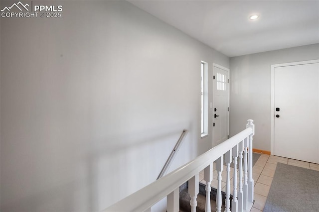 hall featuring light tile patterned floors, baseboards, and recessed lighting