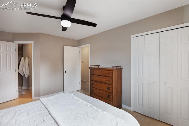 bedroom featuring a closet, baseboards, light wood finished floors, visible vents, and ceiling fan