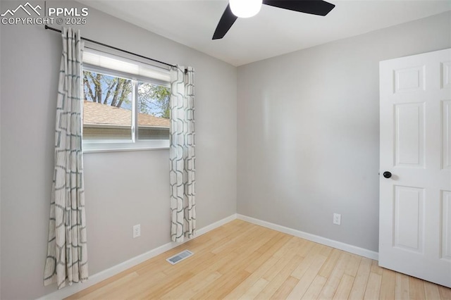 unfurnished room with a ceiling fan, baseboards, visible vents, and wood finished floors
