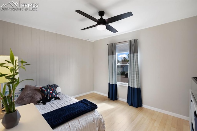 bedroom with baseboards, a ceiling fan, and light wood-style floors