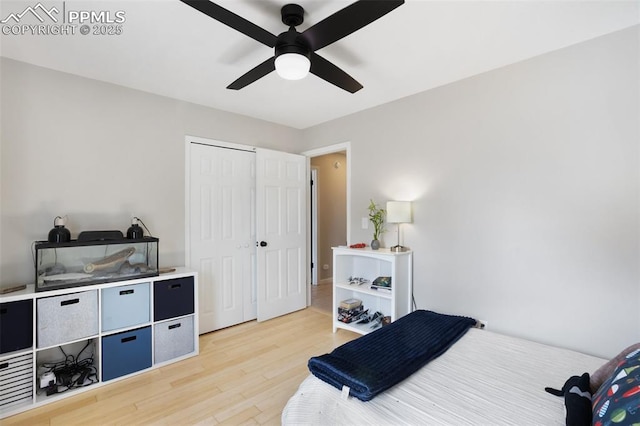 bedroom with ceiling fan, light wood finished floors, and a closet