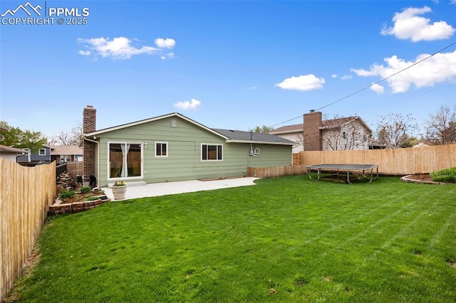 back of house with a yard, a trampoline, and a patio