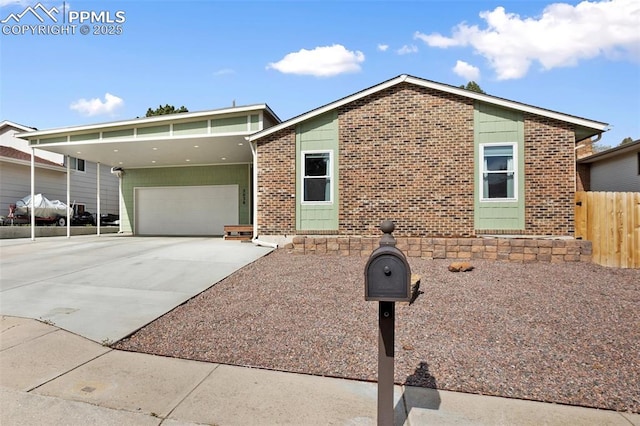 view of front of property featuring fence, a garage, brick siding, and driveway