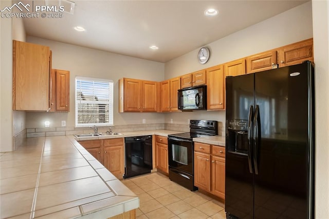 kitchen featuring a sink, light tile patterned floors, black appliances, tile counters, and recessed lighting