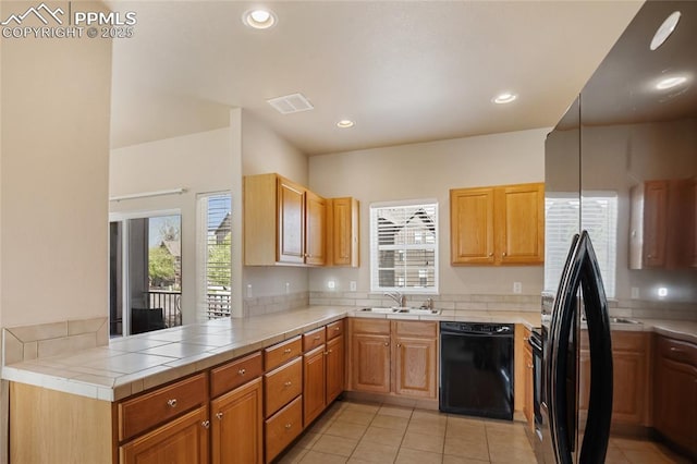 kitchen with a sink, visible vents, black appliances, and a healthy amount of sunlight