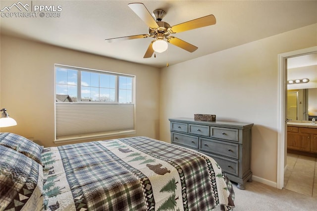 bedroom with baseboards, ceiling fan, light carpet, and connected bathroom
