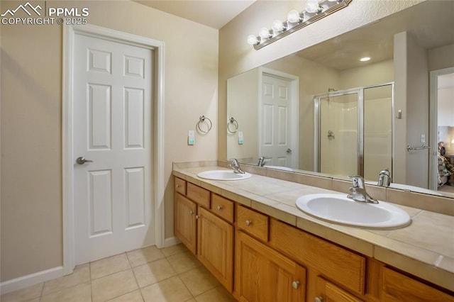 bathroom featuring tile patterned flooring, a sink, a stall shower, and double vanity