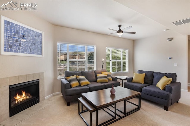 living room with a fireplace, light carpet, a ceiling fan, and visible vents