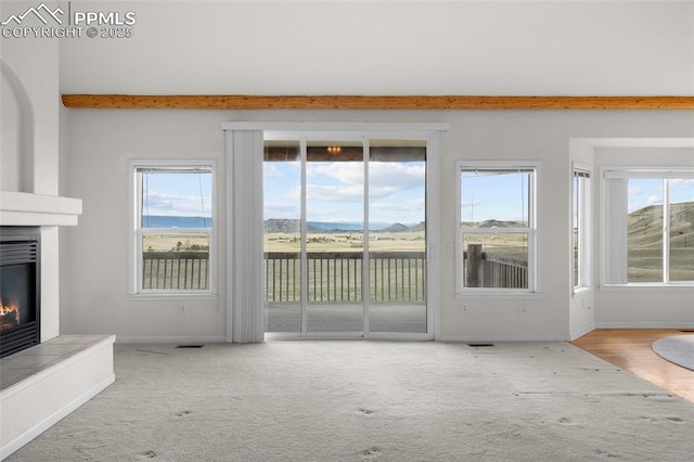 unfurnished living room with baseboards, carpet flooring, visible vents, and a large fireplace
