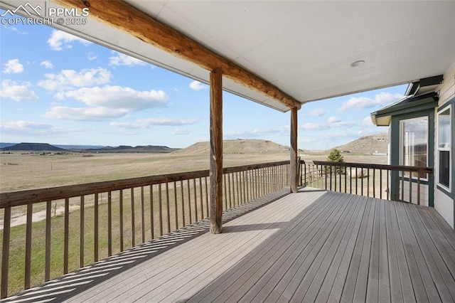 wooden terrace featuring a mountain view and a yard