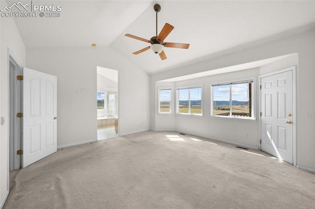 interior space featuring baseboards, multiple windows, carpet, and vaulted ceiling