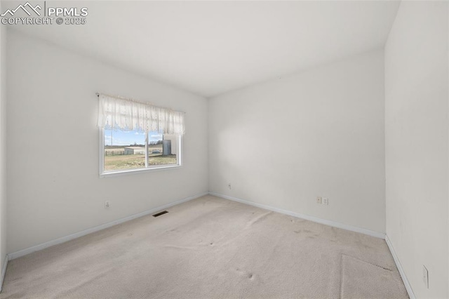 spare room with baseboards, carpet flooring, and visible vents