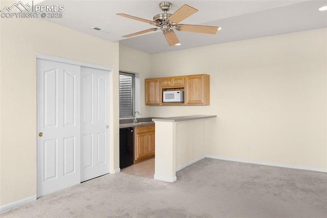 kitchen featuring light colored carpet, dishwasher, baseboards, white microwave, and visible vents