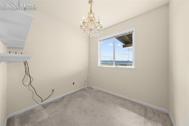 unfurnished dining area with carpet floors, baseboards, and an inviting chandelier